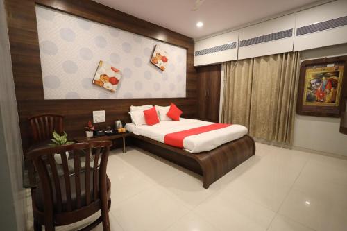 a bedroom with a bed and a chair in it at Hotel Saishree` in Shirdi