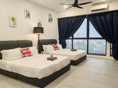 two beds in a hotel room with a window at Bell Suite @ Sepang By MHS in Sepang