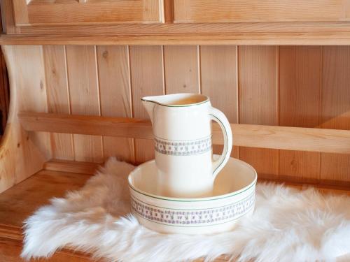 a white coffee cup sitting on a plate on a rug at Farmhouse Bramberg near Wildkogelbahn in Neukirchen am Großvenediger