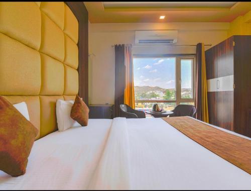 a bedroom with a large bed with a large window at The royal galaxy & Resort in Bedla