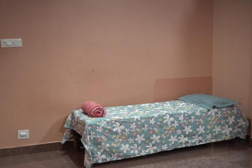 a bedroom with a bed with a green and white blanket at Coorg Stream Side Homestay in Ponnampet