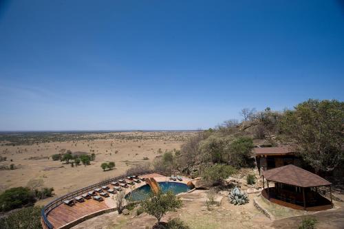 ein Resort mit einem Pool in der Mitte eines Feldes in der Unterkunft Lobo Wildlife Lodge in Serengeti-Savanne