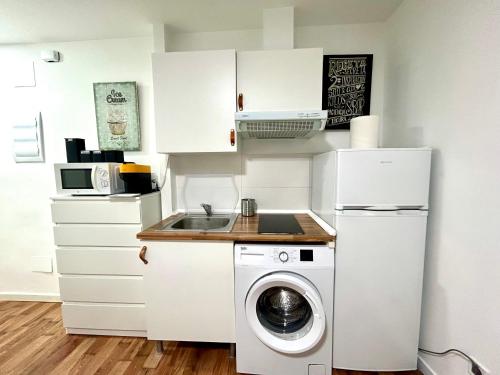 una pequeña cocina con lavadora y fregadero en Bustos Dreams, en Madrid