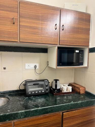a kitchen counter with a microwave and a sink at Villa by the Sea in Mumbai