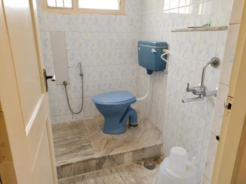 La salle de bains est pourvue de toilettes bleues. dans l'établissement ARL Home Stay, Porur, à Chennai