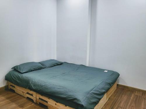 a bed in a white room with a wooden frame at Bcons Garden Luxury Aparment in Dĩ An
