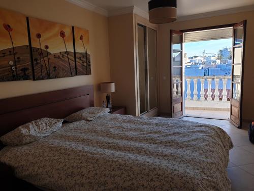 a bedroom with a bed and a window with a view at AS CEGONHAS - ALOJAMENTo LOCAL in Olhão