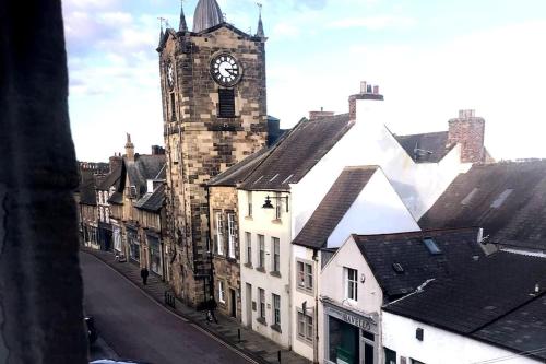 a clock tower in a city with a street at Beautiful holiday flat in Alnwick in Alnwick