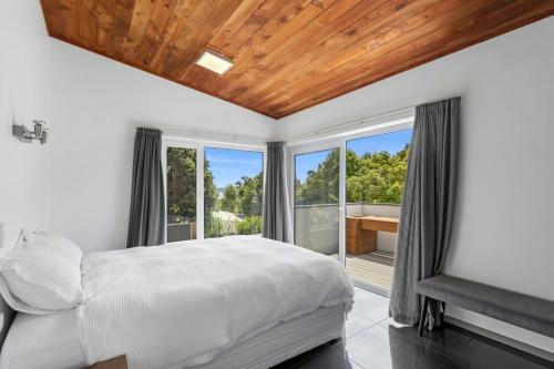 a bedroom with a bed and a balcony with a tub at Bay Vista Retreat in Pohara