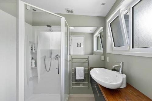 a white bathroom with a sink and a shower at Bay Vista Retreat in Pohara