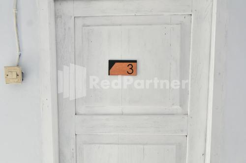 a white door with the number three on it at RedDoorz at Fanta Homestay Lumajang in Sidomukti