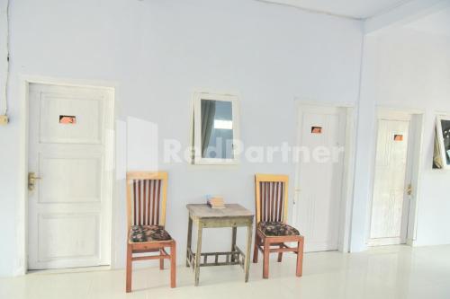 two chairs and a table in a room at RedDoorz at Fanta Homestay Lumajang in Sidomukti