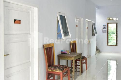 a room with a table and chairs and a door at RedDoorz at Fanta Homestay Lumajang in Sidomukti