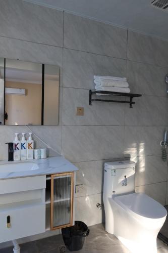 a bathroom with a toilet and a sink and a mirror at shadow climers guest house in Yangshuo