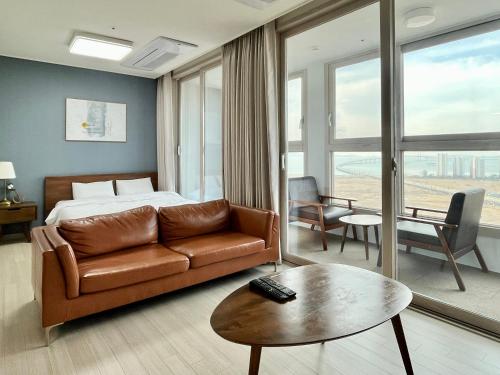 Habitación de hotel con cama, sofá y mesa en Landmark Songdo Stay, en Incheon