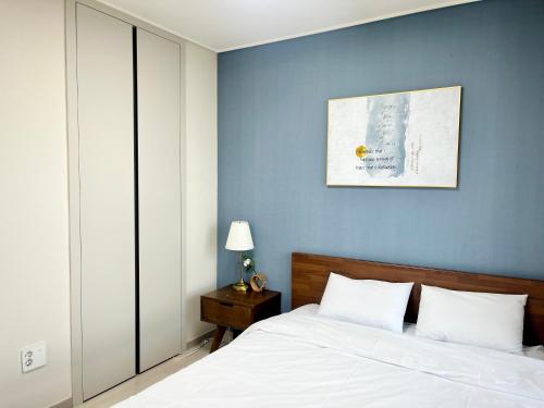 a bedroom with a bed and a blue wall at Landmark Stay in Songdo in Incheon