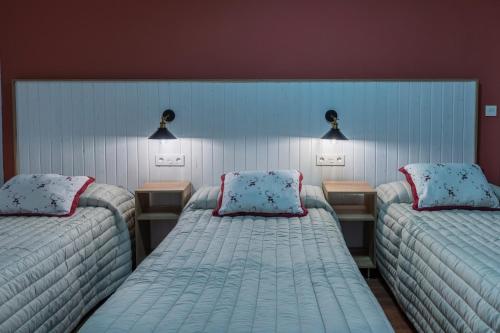 um quarto com duas camas individuais e duas mesas em Hostal Julio Cesar em La Virgen del Camino