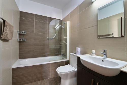 uma casa de banho com um lavatório, um WC e um chuveiro em Mythical Sands Resort - Swahili Apartment em Protaras
