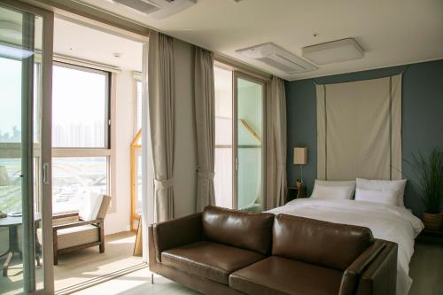 a hotel room with a bed and a couch at Landmark Stay in Songdo in Incheon