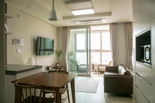 a living room with a table and a couch at Landmark Stay in Songdo in Incheon