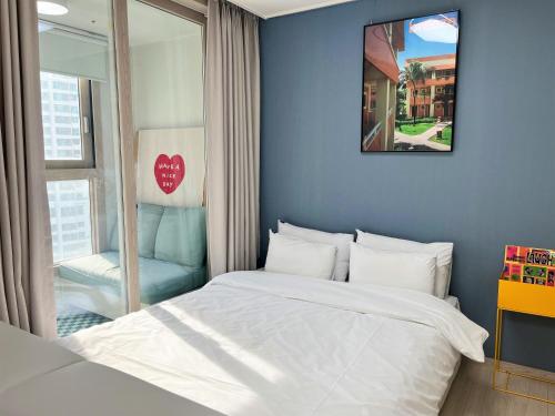 a bedroom with a white bed and a window at Landmark Stay in Songdo in Incheon