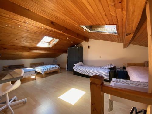 Zimmer mit 2 Betten in einem Zimmer mit Holzdecken in der Unterkunft Petite maison de charme à 1km du lac de Sanguinet et 20min d'Arcachon in Sanguinet