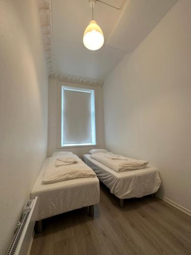 2 camas en una habitación pequeña con ventana en Concept Exodo Apartments en Oslo