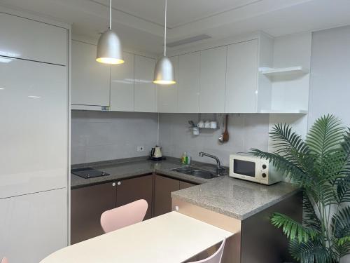 a kitchen with white cabinets and a counter top at Landmark Stay in Songdo in Incheon