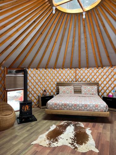 a room with a bed and a stove in a yurt at The Glamping Spot Kalam in Kalām