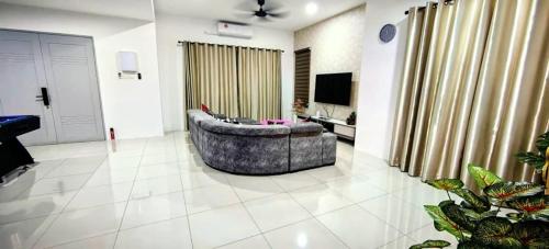 uma sala de estar com um sofá e uma televisão em 19pax Ipoh Semi-D W Shared Pool Table & Karaoke ISD03 R em Ipoh