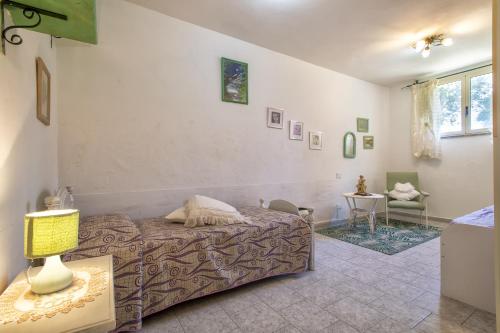 a bedroom with a bed and a table with a lamp at Casa Vale in Viddalba