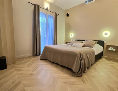 a bedroom with a large bed and a large window at Appart Hotel Cinéma Perpignan in Perpignan