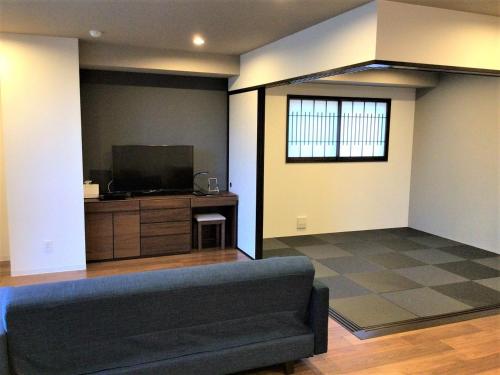 a living room with a couch and a flat screen tv at THE VIEW Odawara shiro-no mieru hotel - Vacation STAY 63560v in Odawara