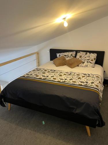 une chambre avec un grand lit avec des oreillers dessus dans l'établissement Appartement confort à Cholet, à Cholet