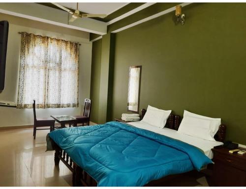a bedroom with a large bed with a blue blanket at Hotel Ranthambhore Palace, Sawai Madhopur, RJ in Sawāi Mādhopur