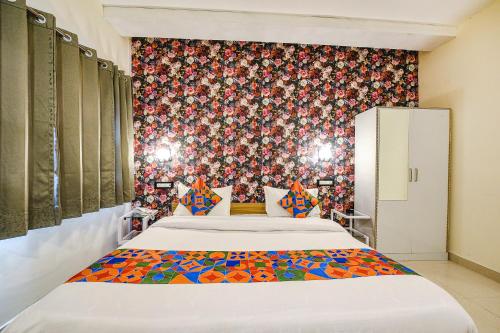 a bedroom with a bed and a floral wall at FabHotel Sizzling Resort & Adventure in Dhanaulti