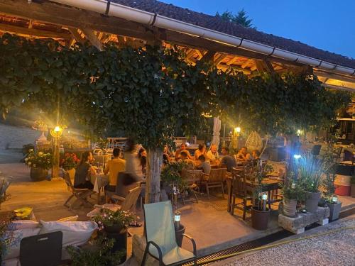 un grupo de personas sentadas en un restaurante por la noche en GITE de GROUPE Le Domaine de Maumont, en Milhac-de-Nontron