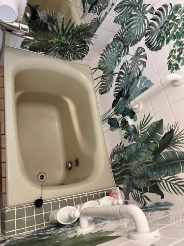 a sink in a bathroom with green plants on the wall at Jonni`s Place in Sakamoto