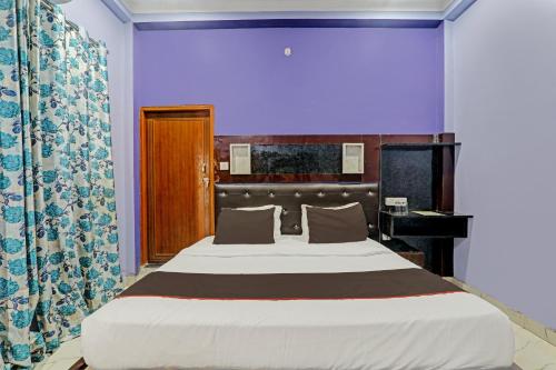 a large bed in a room with a purple wall at OYO Flagship 81544 Hotel Drip Inn in Lucknow