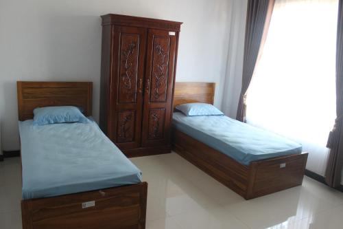 - 2 lits jumeaux dans une chambre avec fenêtre dans l'établissement Lutjanus Guest House, à Majangan