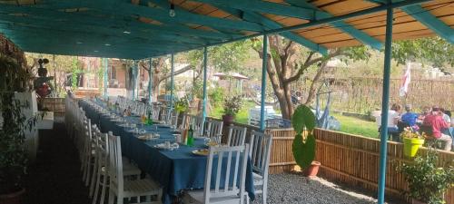 a long blue table with white chairs under a tent at Lunisi Kvareli in Kvareli