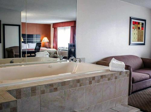 a large bath tub in a room with a couch at Norwood Inn Statefare Grounds in Columbus