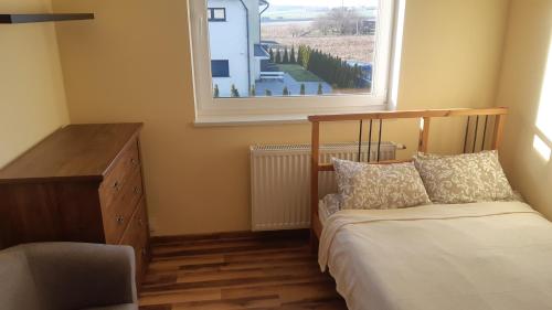 - une chambre avec un lit, une commode et une fenêtre dans l'établissement dom wypoczynkowy 10min autobusem od Starówki, à Gdańsk