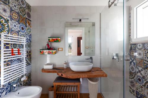 uma casa de banho com um lavatório e um chuveiro em Sunny House Trilo with Pool - Happy Rentals em Sanarica