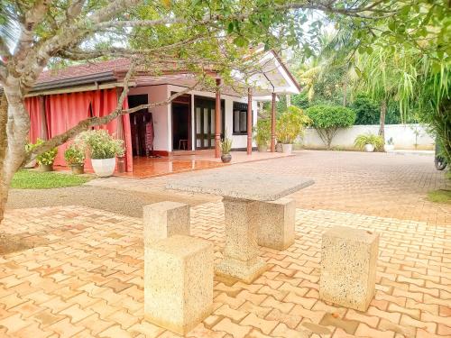 una panchina di pietra di fronte a una casa di Royal Princess Holiday Inn a Alutgama