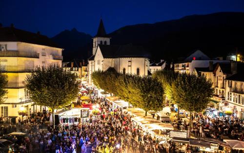 a crowd of people walking around a market at night at Gîte l'angélique Fleurs des Pyrénées in Argelès-Gazost