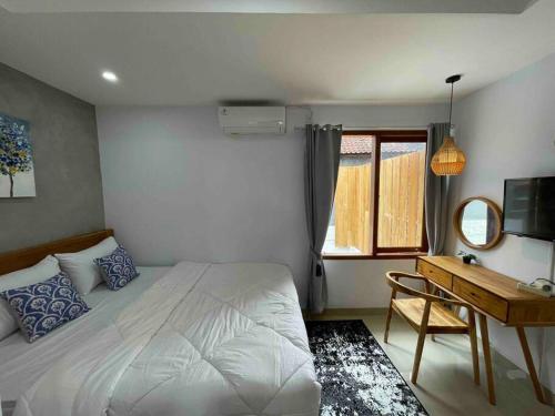 1 dormitorio con cama, escritorio y ventana en LaKalena Private Villa Bali, en Ketewel