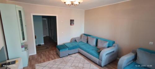 ein Wohnzimmer mit einem blauen Sofa und 2 Stühlen in der Unterkunft Lux Home на берегу Ульбы in Öskemen