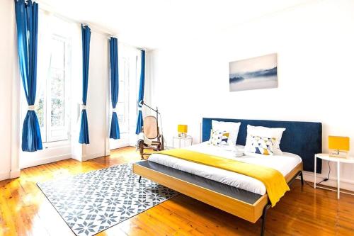 une chambre avec un grand lit avec des rideaux bleus dans l'établissement L'impressionniste-Charme de l'ancien-Hypercentre, à Nantes