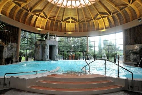 a swimming pool in a large building with a fountain at Chez Welter in Argelès-Gazost